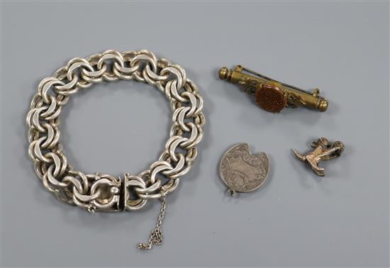 A silver double link bracelet, two white metal pendant charms and a goldstone set metal brooch.